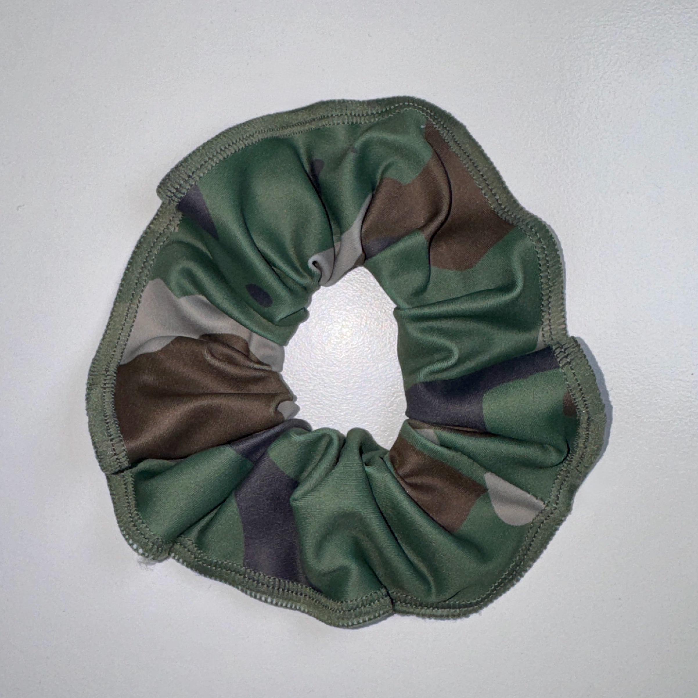 Camouflage-patterned scrunchie on a light gray background